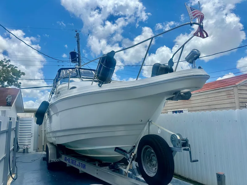 Slide: The Image of 2001 Regal Commodore 2760 boat on trailer, parked in driveway under blue sky. - 6