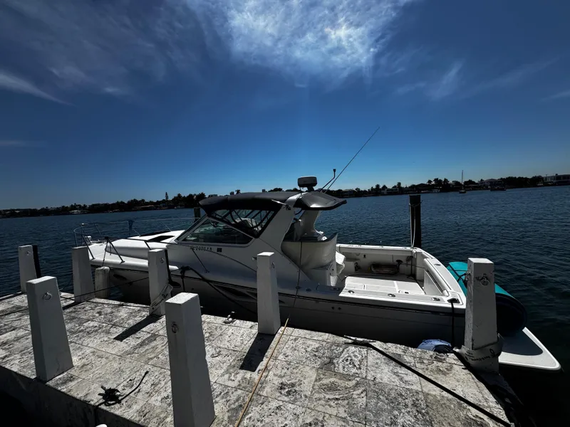 Slide: The Image of 2000 Tiara Yachts 3500 Open docked by the water under a clear blue sky. - 10