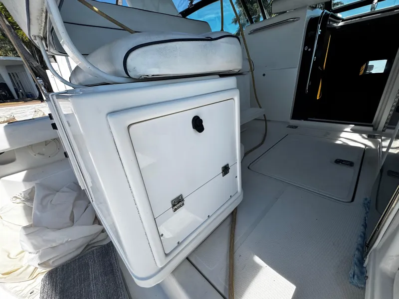 Slide: The Image of 2000 Tiara Yachts 3500 Open interior, featuring white seating and storage compartment. - 18