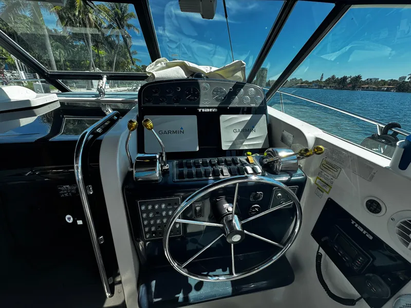 Slide: The Image of Helm of 2000 Tiara Yachts 3500 Open with Garmin navigation, overlooking serene waters. - 22