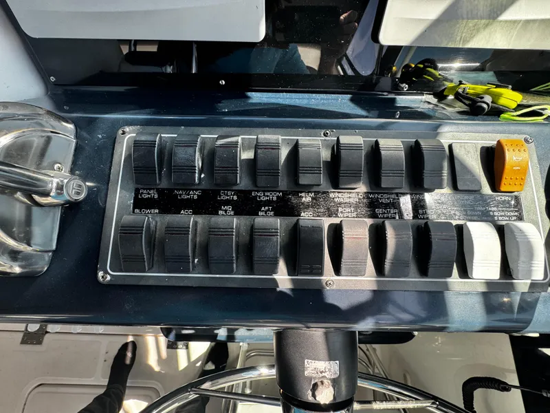Slide: The Image of Control panel of a 2000 Tiara Yachts 3500 Open, featuring various switches and levers. - 24