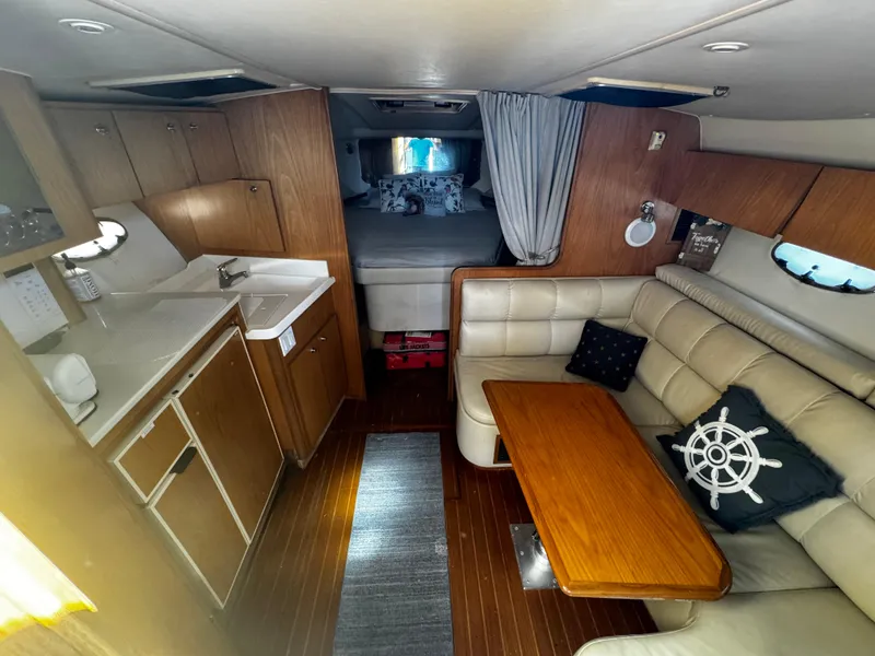 Slide: The Image of Interior of 2000 Tiara Yachts 3500 Open, featuring kitchen, seating, and sleeping area. - 33