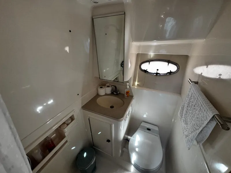Slide: The Image of Bathroom interior of 2000 Tiara Yachts 3500 Open, featuring sink, toilet, and porthole. - 34