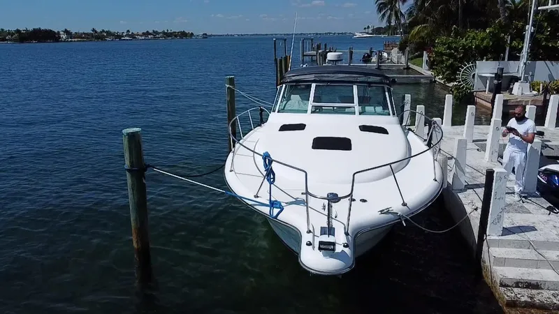 Slide: The Image of 2000 Tiara Yachts 3500 Open docked by a waterfront, clear blue sky. - 4