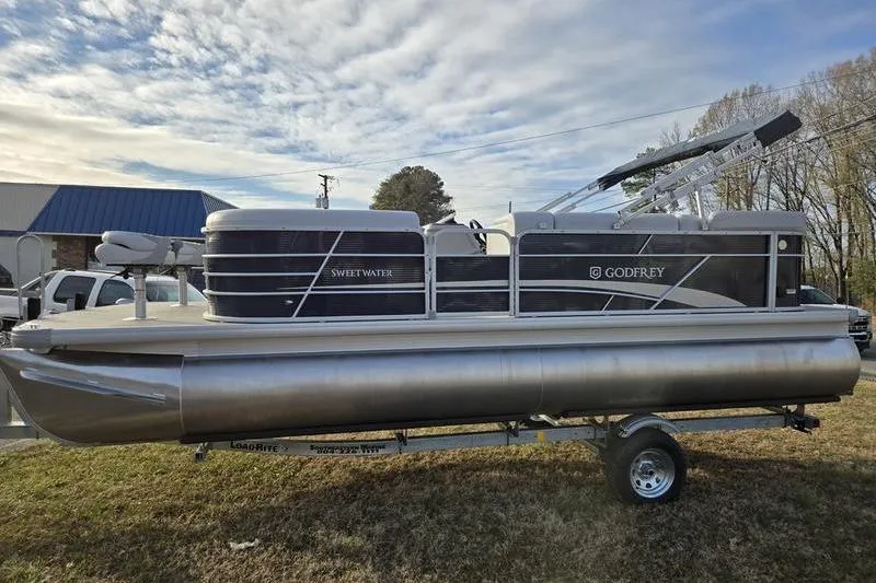 The Image of 2022 Godfrey Sweetwater 2286 BF pontoon boat on trailer, parked outdoors. - 0
