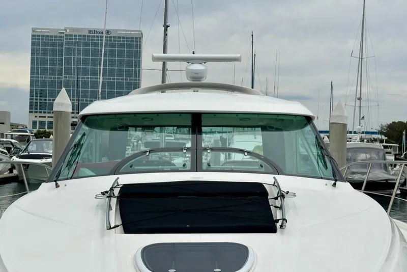 The Image of 2011 Sea Ray 450 Sundancer yacht docked at marina with Hilton hotel in background. - 0
