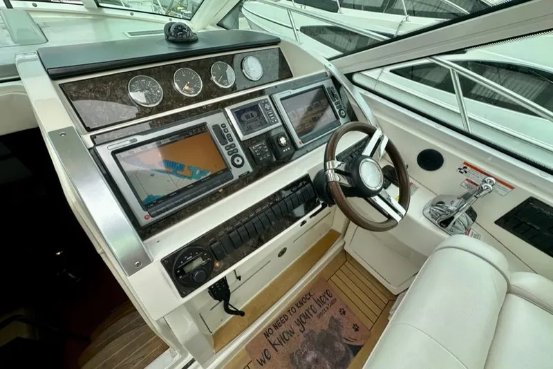Slide: The Image of Cockpit of 2011 Sea Ray 450 Sundancer with navigation system and steering wheel. - 12