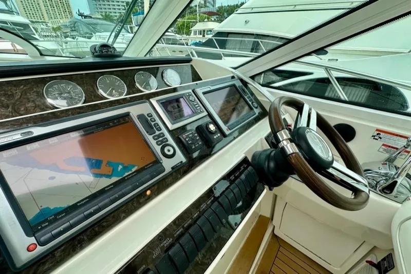 Slide: The Image of 2011 Sea Ray 450 Sundancer helm with navigation screens and controls. - 13