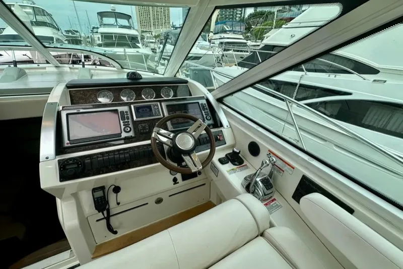 Slide: The Image of Helm of 2011 Sea Ray 450 Sundancer yacht with navigation equipment and marina view. - 14