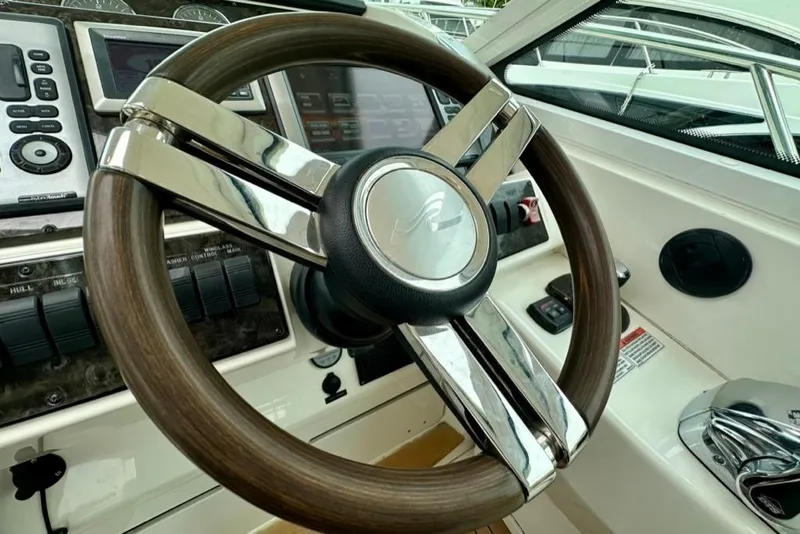 Slide: The Image of Steering wheel of a 2011 Sea Ray 450 Sundancer yacht, featuring sleek design and controls. - 17