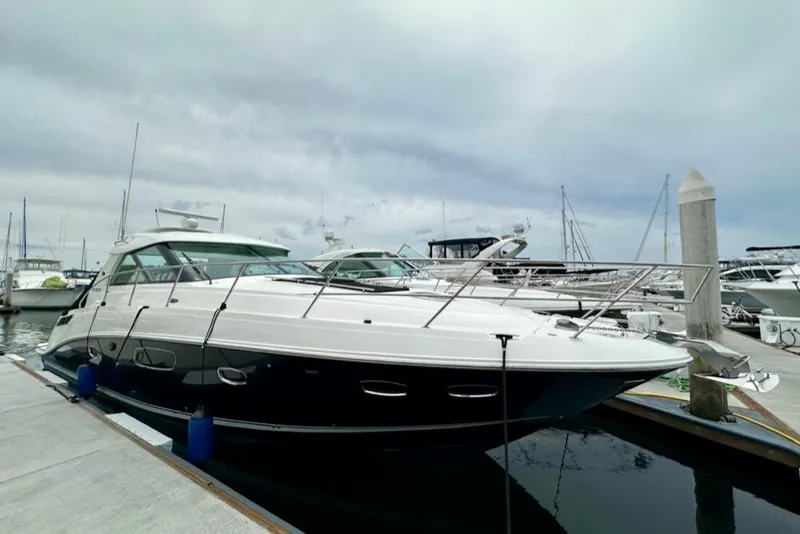 Slide: The Image of 2011 Sea Ray 450 Sundancer yacht docked at marina under cloudy sky. - 2