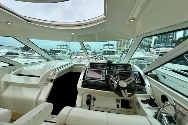 Slide: The Image of Interior view of 2011 Sea Ray 450 Sundancer yacht cockpit with marina backdrop. - 24