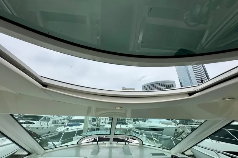 Slide: The Image of 2011 Sea Ray 450 Sundancer yacht interior with panoramic sunroof and marina view. - 28