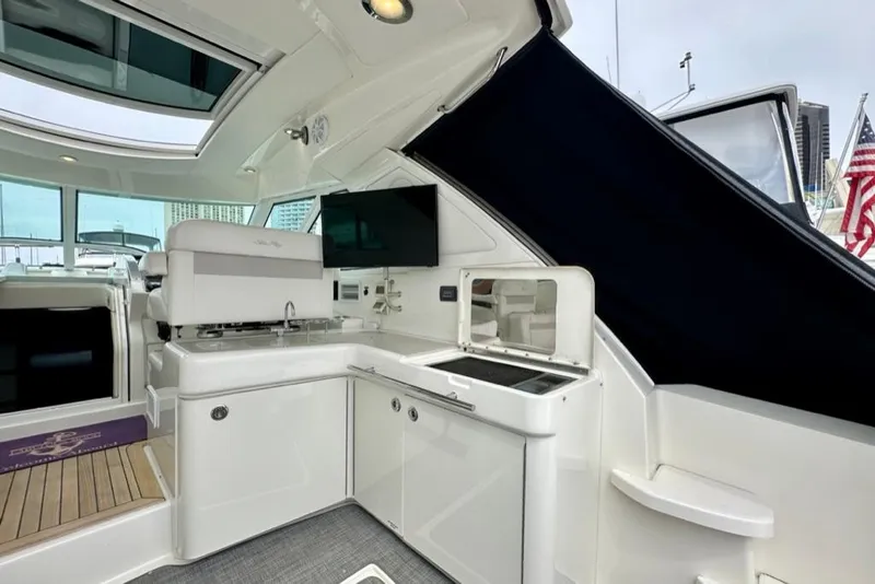Slide: The Image of Interior of 2011 Sea Ray 450 Sundancer yacht with kitchenette and seating area. - 31