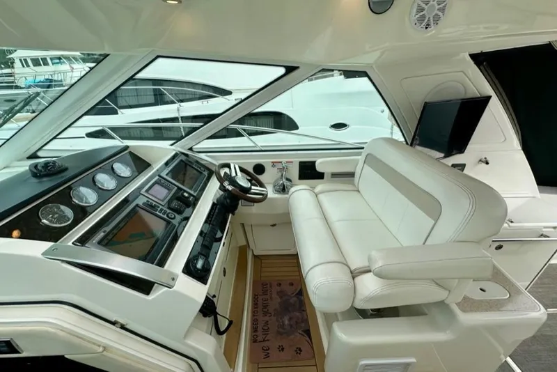 Slide: The Image of Helm of 2011 Sea Ray 450 Sundancer with modern controls and white seating. - 34