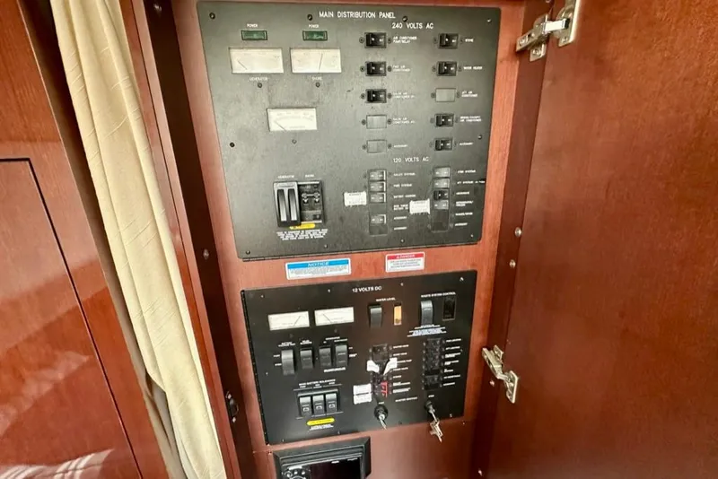 Slide: The Image of Electrical panel inside 2011 Sea Ray 450 Sundancer yacht, featuring various switches and controls. - 36