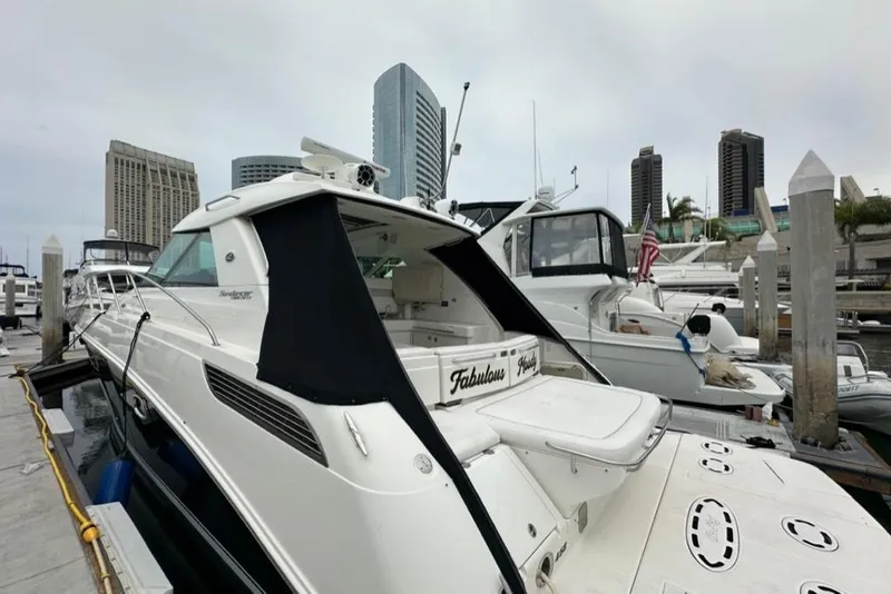 Slide: The Image of 2011 Sea Ray 450 Sundancer yacht docked in marina with city skyline background. - 43