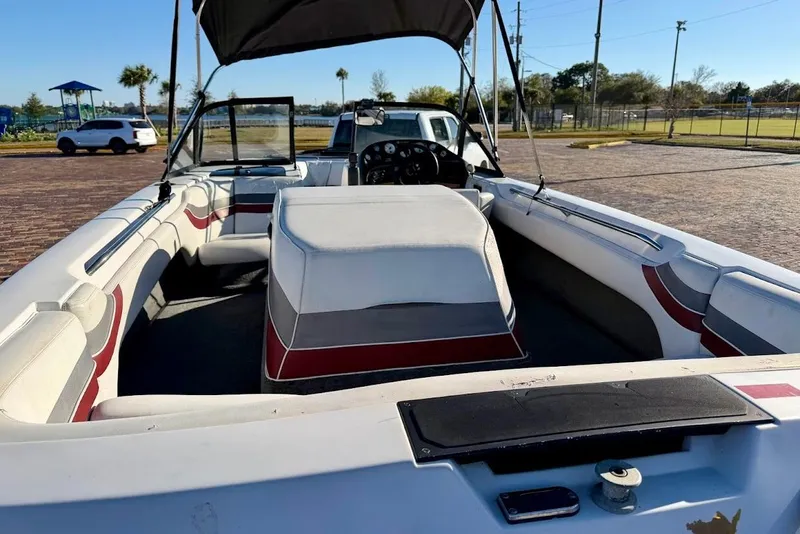 Slide: The Image of 1993 Correct Craft Sport Nautique boat interior with seating and dashboard, parked outdoors. - 9