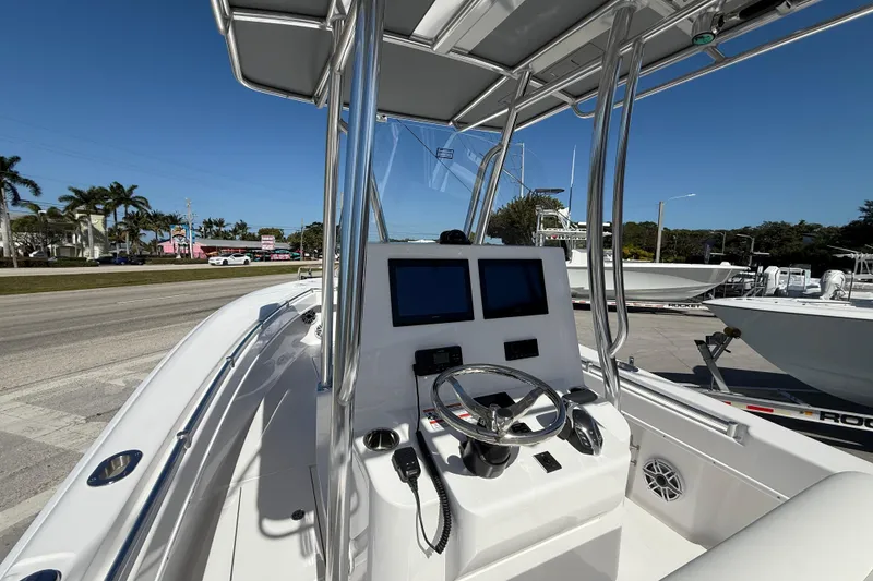 Slide: The Image of 2026 Contender 25 Tournament boat console with dual screens and steering wheel, docked outdoors. - 4