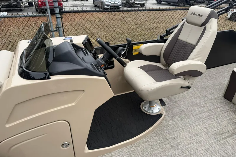 Slide: The Image of 2026 Bentley Pontoons Elite 253 Swingback helm with luxurious captain's chair and sleek dashboard. - 4