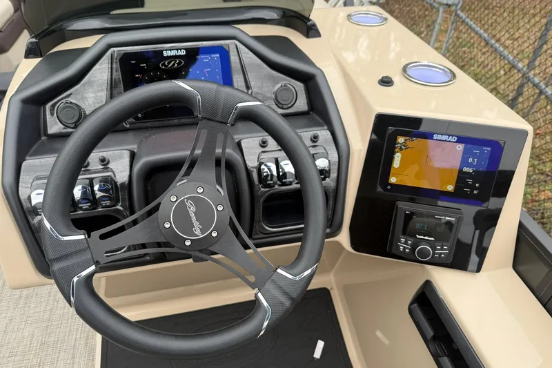 Slide: The Image of 2026 Bentley Pontoons Elite 253 Swingback dashboard with steering wheel and Simrad displays. - 5