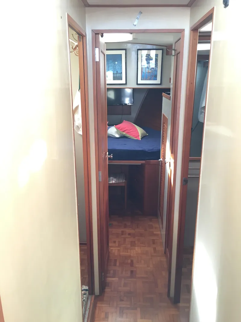 Slide: The Image of Interior of 1982 Grand Banks 42 Europa, featuring wood flooring and cozy bedroom. - 34
