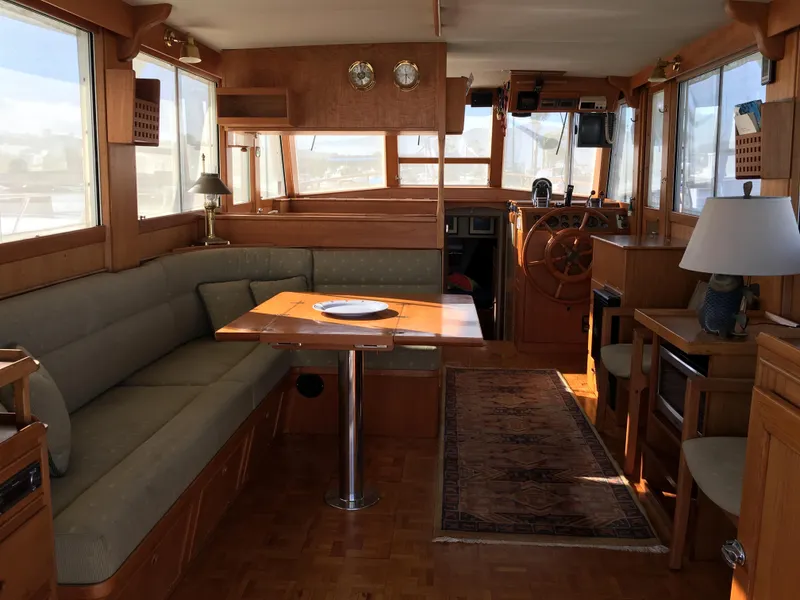 Slide: The Image of Interior of a 1982 Grand Banks 42 Europa yacht, featuring wood furnishings and helm area. - 9