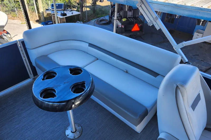 Slide: The Image of 2022 Godfrey Sweetwater 2286 SFL boat interior with seating and cup holder table. - 28