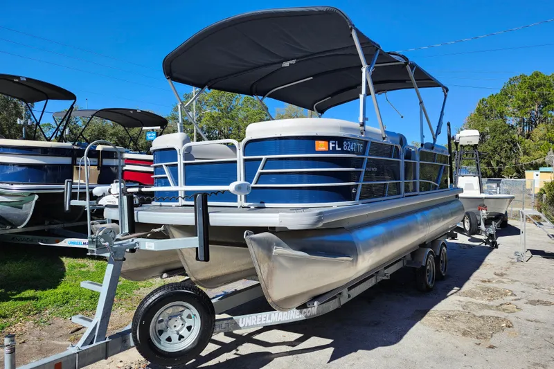 Slide: The Image of 2022 Godfrey Sweetwater 2286 SFL pontoon boat on trailer, blue and white design. - 3