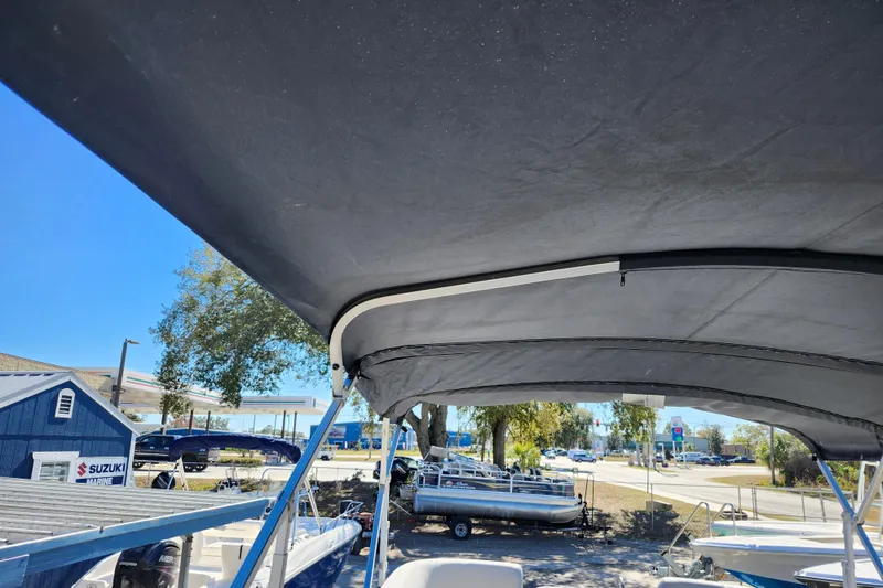 Slide: The Image of 2022 Godfrey Sweetwater 2286 SFL boat with canopy, parked near Suzuki Marine dealership. - 38