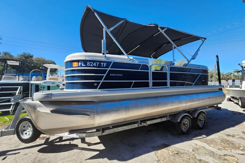 Slide: The Image of 2022 Godfrey Sweetwater 2286 SFL pontoon boat on trailer, under clear blue sky. - 4