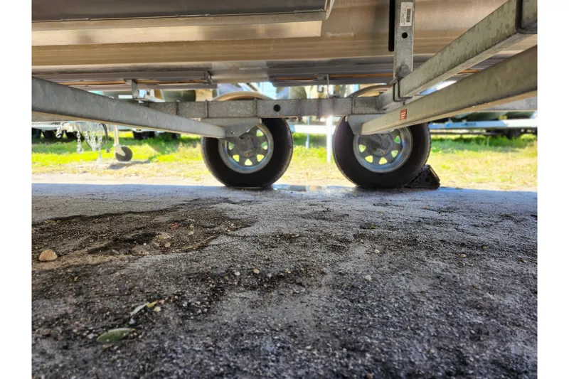 Slide: The Image of Underneath view of 2022 Godfrey Sweetwater 2286 SFL trailer wheels on gravel. - 45