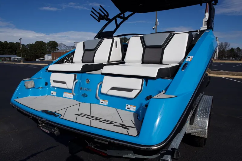 Slide: The Image of 2023 Yamaha Boats 255XD, blue exterior, rear view with seating and swim platform. - 25