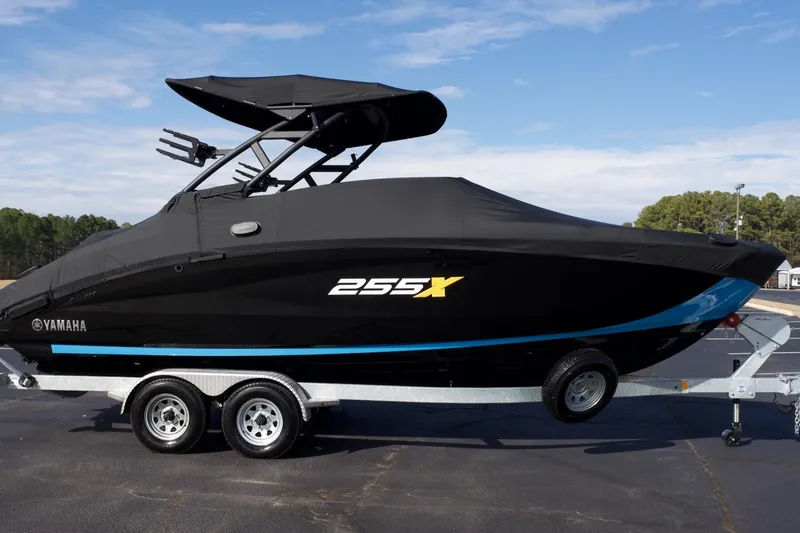 Slide: The Image of 2023 Yamaha Boats 255XD, black, on trailer, covered, outdoor setting. - 28
