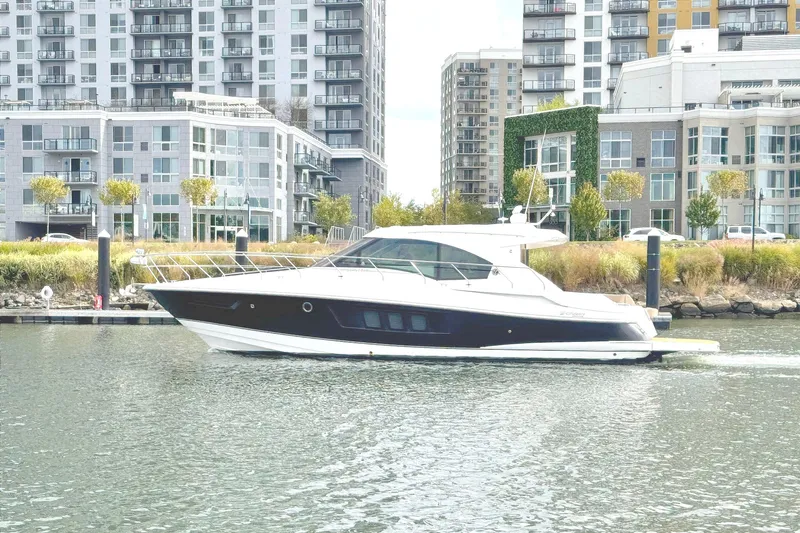 Slide: The Image of 2014 Cruisers Yachts 45 Cantius on water near modern city buildings. - 2