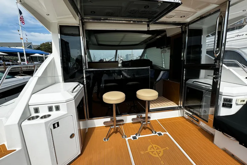 Slide: The Image of 2014 Cruisers Yachts 45 Cantius cockpit with bar stools and sliding glass doors. - 5