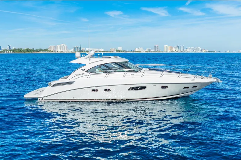 The Image of 2009 Sea Ray 470 Sundancer yacht cruising on blue ocean near city skyline. - 1