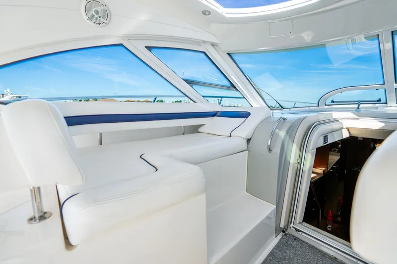 Slide: The Image of Interior view of 2009 Sea Ray 470 Sundancer yacht with white seating and large windows. - 17