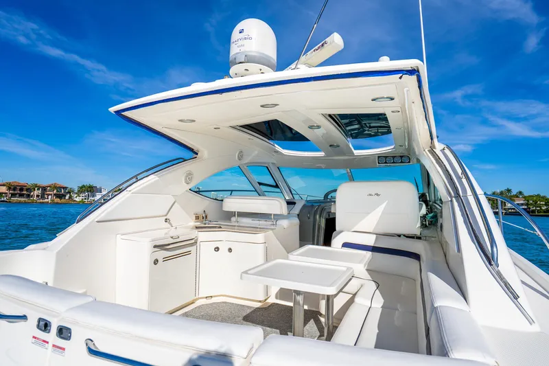 Slide: The Image of 2009 Sea Ray 470 Sundancer yacht interior with seating, table, and blue sky background. - 22