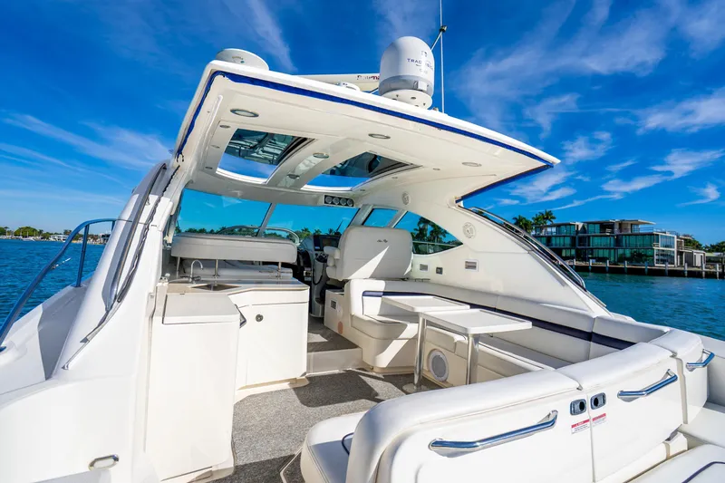 Slide: The Image of 2009 Sea Ray 470 Sundancer yacht interior with seating, table, and blue sky background. - 23