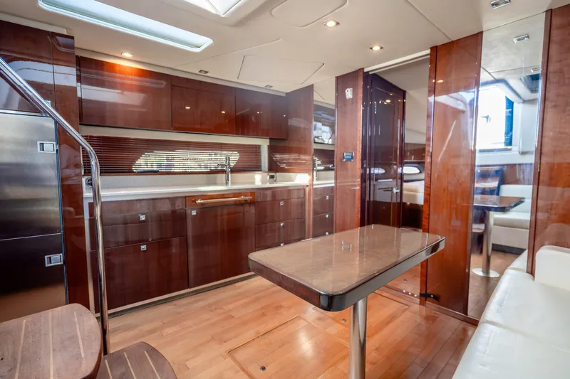Slide: The Image of Luxurious interior of 2009 Sea Ray 470 Sundancer yacht with modern kitchen and dining area. - 26