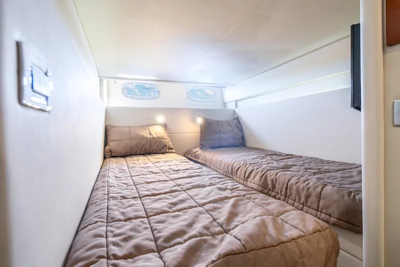 Slide: The Image of 2009 Sea Ray 470 Sundancer cabin with twin beds and soft lighting. - 38