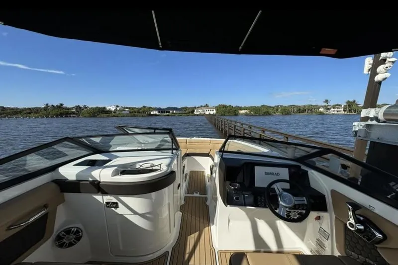 Slide: The Image of 2024 Sea Ray SDX 270 boat anchor compartment with open hatch, dock in background. - 13