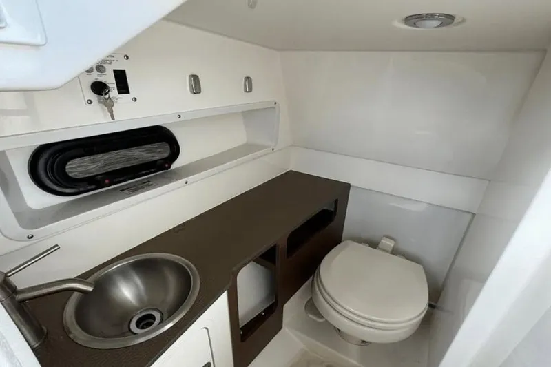 Slide: The Image of 2024 Sea Ray SDX 270 interior with tan seating and wood-style flooring. - 16