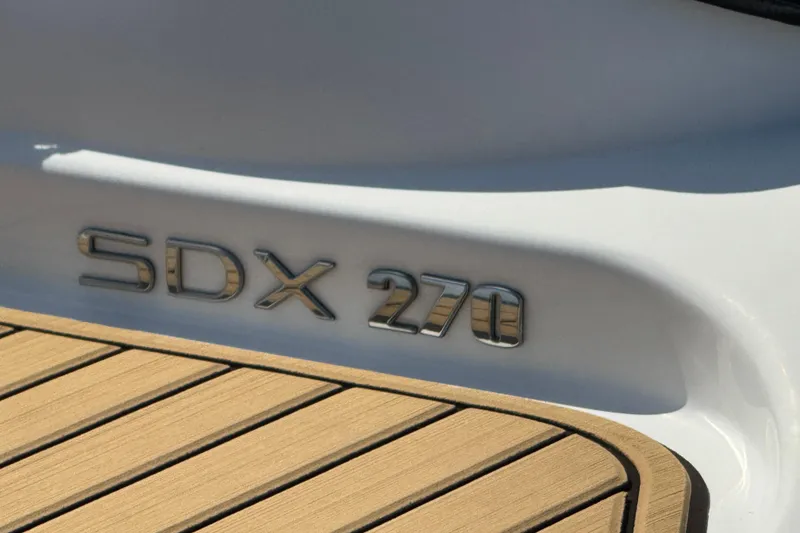 Slide: The Image of Luxurious seating on 2024 Sea Ray SDX 270 boat with tan upholstery and wood-style flooring. - 20
