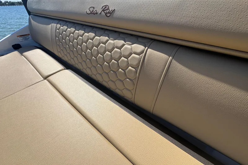 Slide: The Image of 2024 Sea Ray SDX 270 boat interior with beige leather seating and hexagonal pattern design. - 30