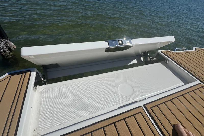 Slide: The Image of 2024 Sea Ray SDX 270 swim platform with teak-style decking on water. - 49