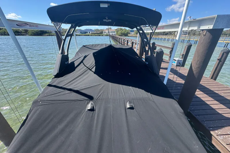 Slide: The Image of 2024 Sea Ray SDX 270 boat covered at dock, sunny day, calm water. - 54