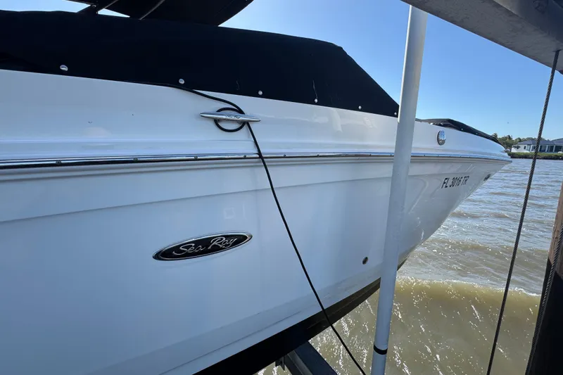 Slide: The Image of 2024 Sea Ray SDX 270 boat docked by the water on a sunny day. - 7