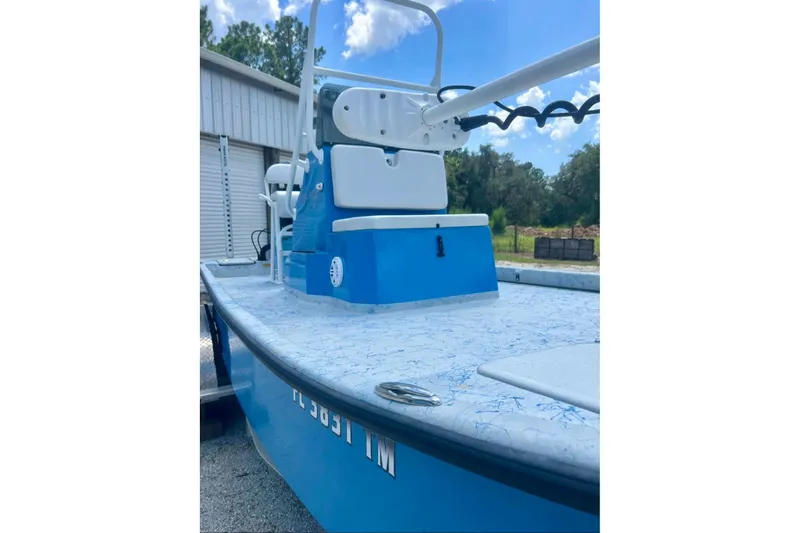 Slide: The Image of 2022 Flats Cat 21' boat with blue and white design, parked outdoors. - 5